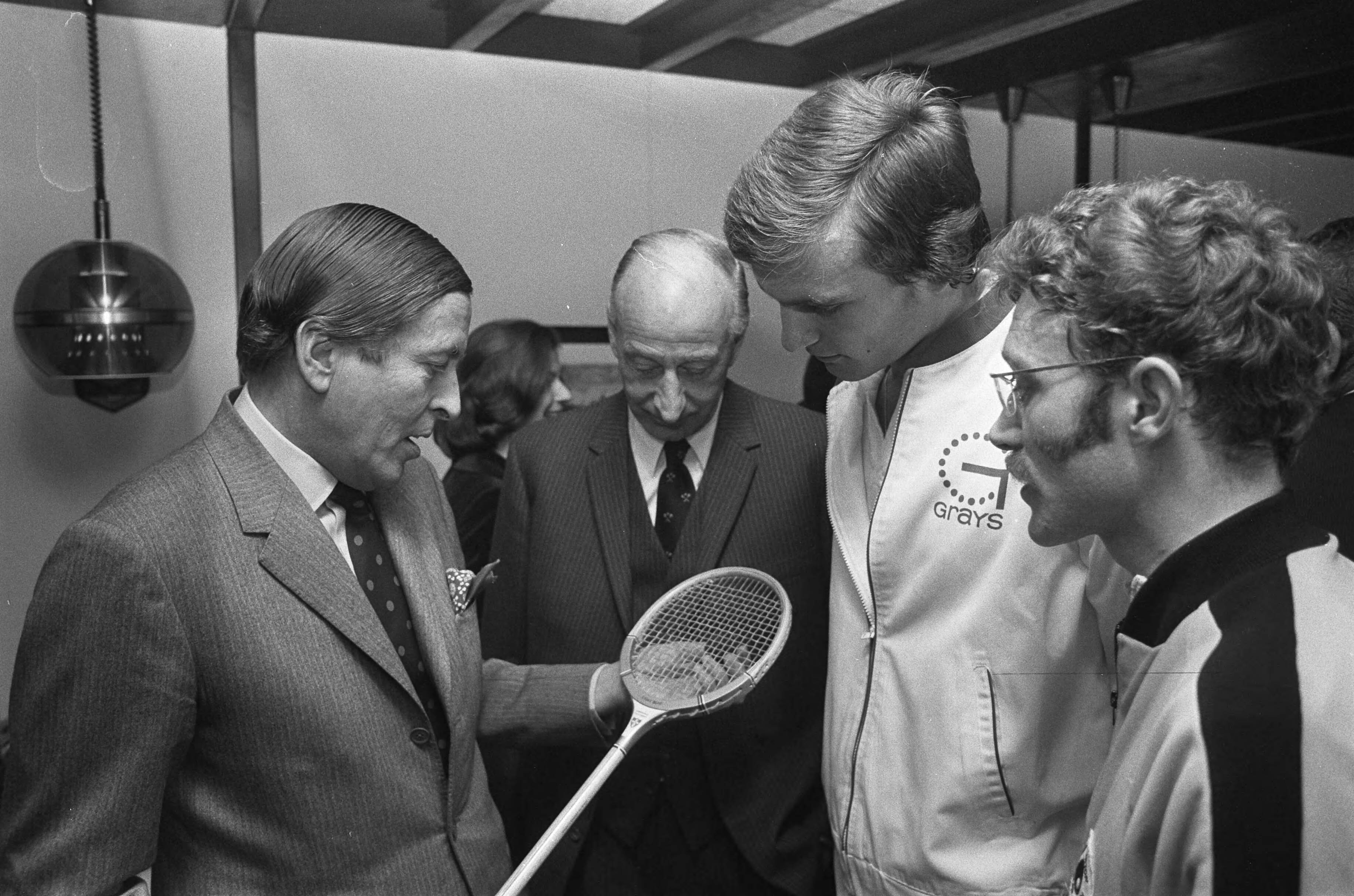 Prins Claus opent het squash kampioenschap voor amateurs in Den Haag — De prins bekijkt een racket — Foto: Fotograaf Onbekend / Anefo. Licentie: Set B: Rechtenvrij / Publiek Domein. Bron: Nationaal Archief. http://hdl.handle.net/10648/ac3bfd3a-d0b4-102d-bcf8-003048976d84