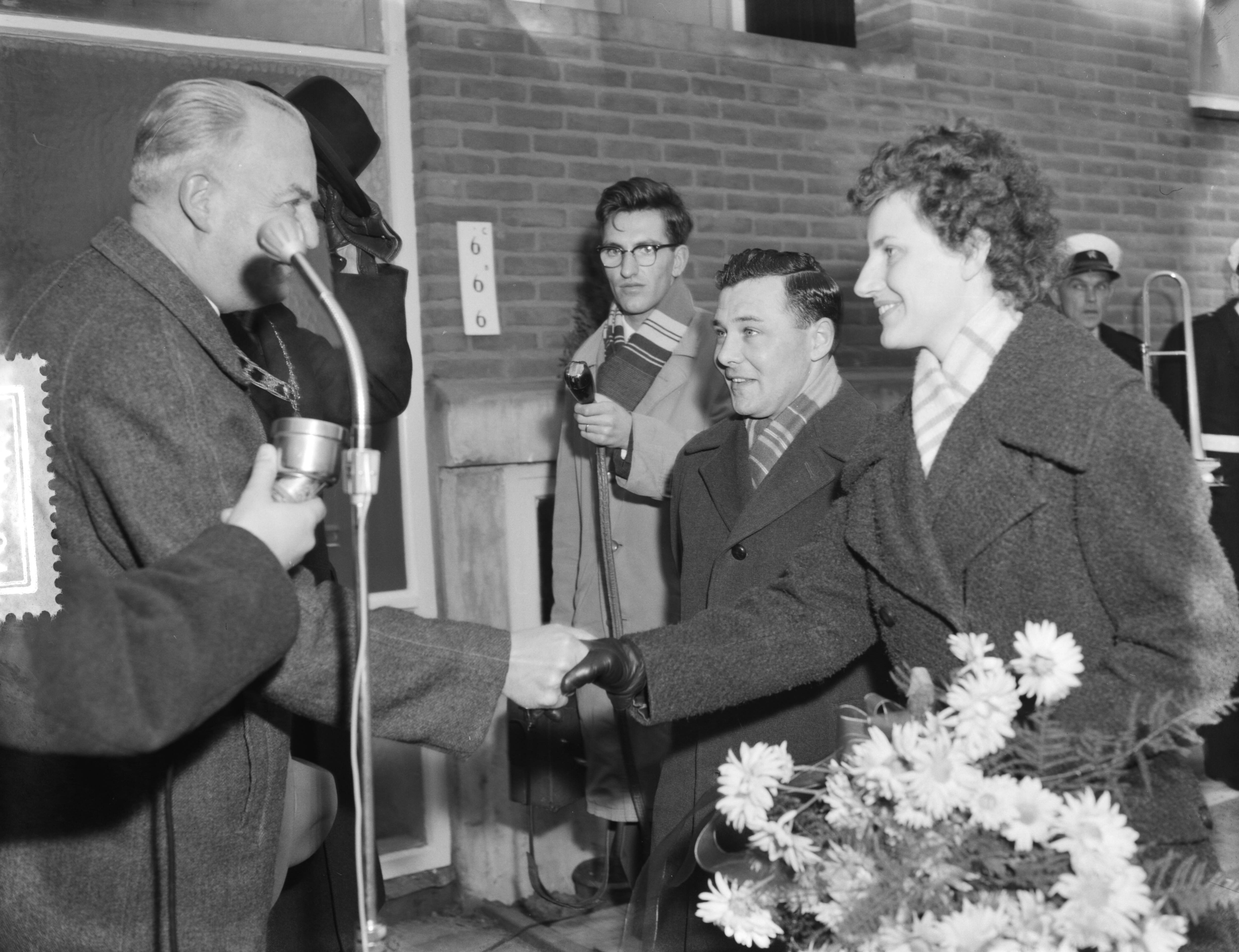 Fotocollectie Anefo — 5000ste na-oorlogse woning te Leeuwarden gereed gekomen. Betreft Beukenstraat nr. 6 in de buurt Heechterp, bewoners de familie Burger. Ir. D. Visser, hoofdingenieur-directeur van Volkshuisvesting en Bouwnijverheid in Friesland, overhandigde de sleutel. Hij schudt de hand van mevr. Burger — Foto: Rossem, Wim van / Anefo. Licentie: Set B: Rechtenvrij / Publiek Domein. Bron: Nationaal Archief. http://hdl.handle.net/10648/a9a2bd0c-d0b4-102d-bcf8-003048976d84