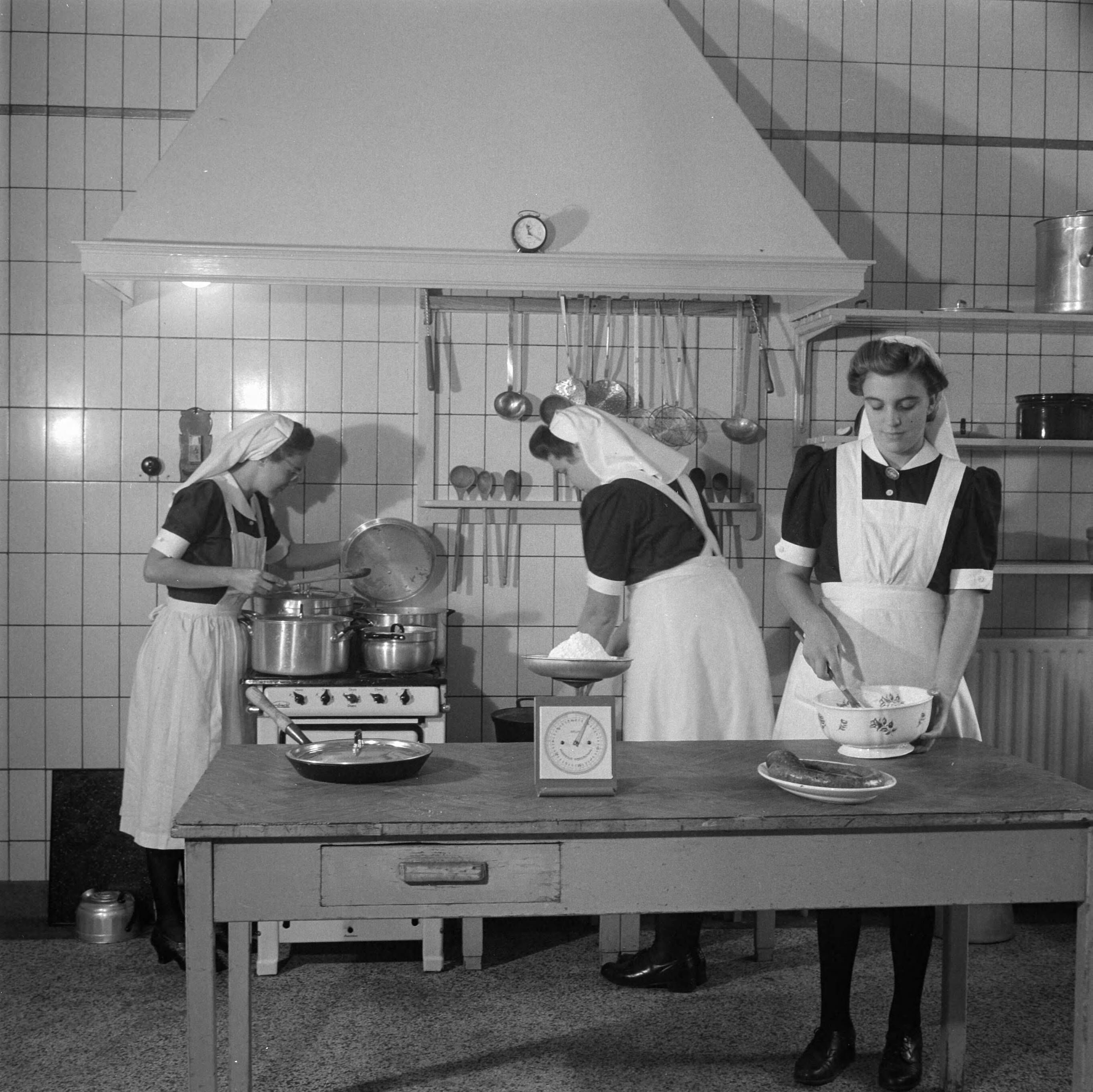 Verpleegstersschool — De eerste Katholieke Opleiding voor Verpleegkundigen in Park Vronesteyn in Voorburg. Drie verpleegkundigen staan in de keuken te koken. — Foto: Wisman, Bram / Anefo. Licentie: Set B: Rechtenvrij / Publiek Domein. Bron: Nationaal Archief. http://hdl.handle.net/10648/a8ae42b8-d0b4-102d-bcf8-003048976d84