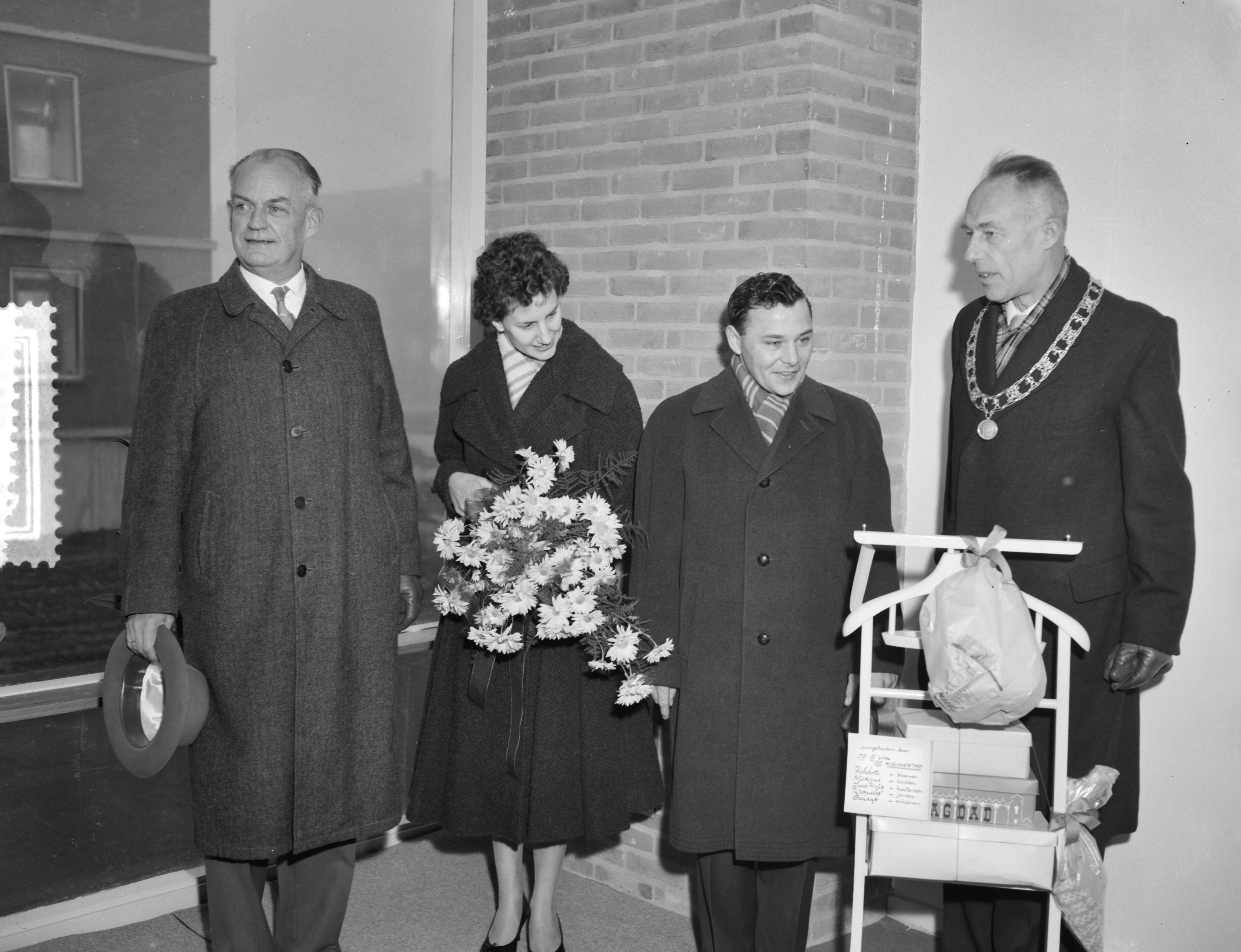 Fotocollectie Anefo — 5000ste na-oorlogse woning te Leeuwarden gereed gekomen. Betreft Beukenstraat nr. 6 in de buurt Heechterp, bewoners de familie Burger. Vlnr. Ir. D. Visser, hoofdingenieur-directeur van Volkshuisvesting en Bouwnijverheid in Friesland, mevrouw Burger, de heer Burger en burgemeester A.A.M. van der Meulen staande achter enige cadeau's — Foto: Rossem, Wim van / Anefo. Licentie: Set B: Rechtenvrij / Publiek Domein. Bron: Nationaal Archief. http://hdl.handle.net/10648/a9a2be7e-d0b4-102d-bcf8-003048976d84