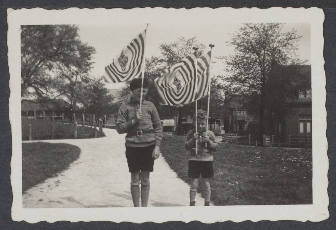 AVRO (Algemene Vereniging Radio Omroep). Bijzondere gebeurtenissen - Nederland — Hoe de wind ook rukken mag. Hou vast! De Avro-vlag 14-5-'31 (Leeuwarden) — Foto: Onbekend / Publiek Domein of Rechtenvrij. Licentie: Set B: Rechtenvrij / Publiek Domein. Bron: Nationaal Archief. http://hdl.handle.net/10648/710863c9-2728-d4d8-e6f8-185bdad2d2b3