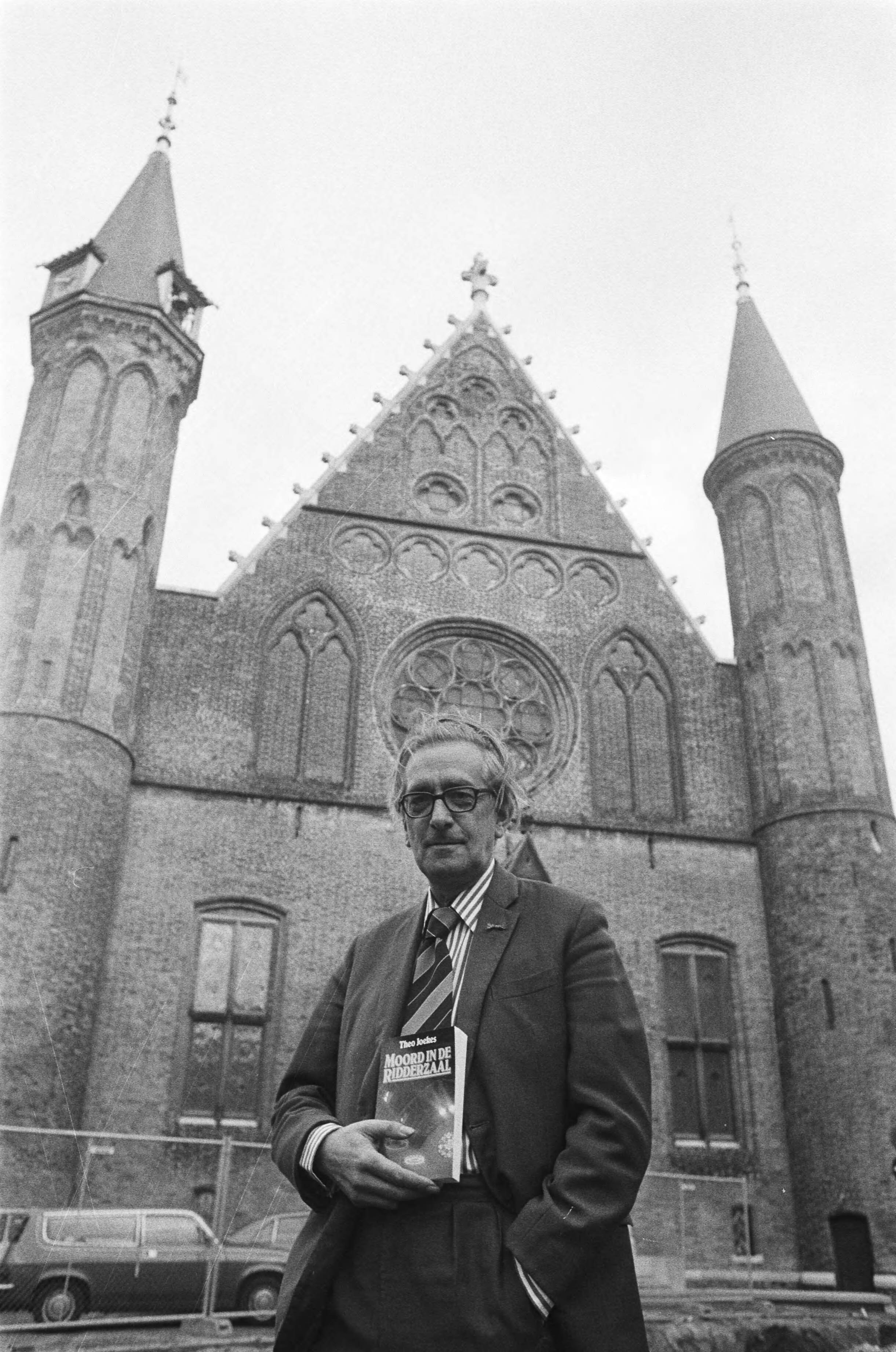 Presentatie van "Moord in de Ridderzaal" van Tweede Kamerlid Joekes (VVD) in Den Haag — Joekes met zijn boek voor Ridderzaal — Foto: Bogaerts, Rob / Anefo. Licentie: Set B: Rechtenvrij / Publiek Domein. Bron: Nationaal Archief. http://hdl.handle.net/10648/acede16c-d0b4-102d-bcf8-003048976d84
