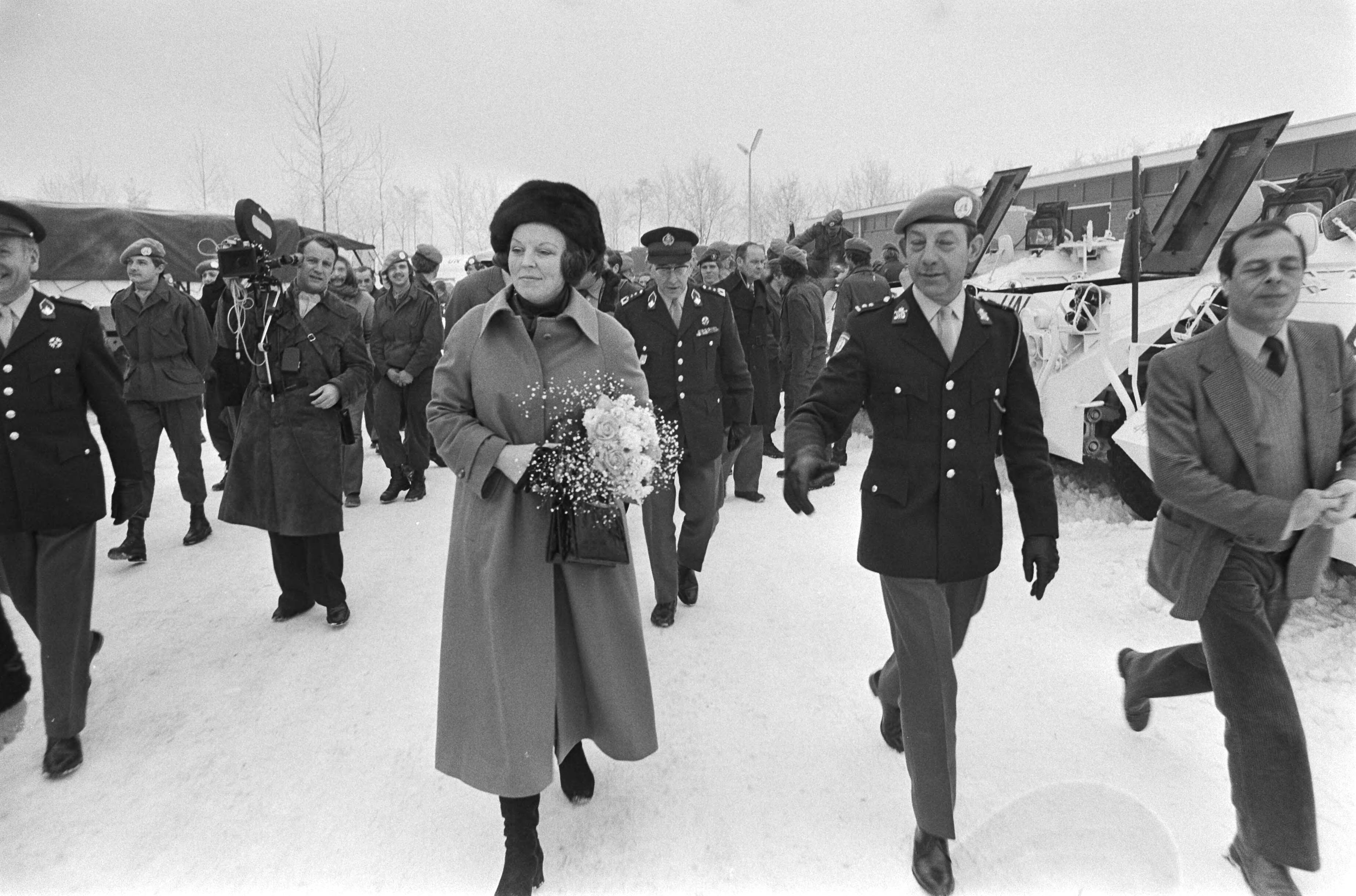 Prinses Beatrix en prins Claus bezoeken VN detachement voor Libanon in de Adolf van Nassau kazerne in Zuidlaren — Prinses Beatrix en prins Claus lopen met enige officieren over een besneeuwd pad — Foto: Suyk, Koen / Anefo. Licentie: Set B: Rechtenvrij / Publiek Domein. Bron: Nationaal Archief. http://hdl.handle.net/10648/acc4d114-d0b4-102d-bcf8-003048976d84