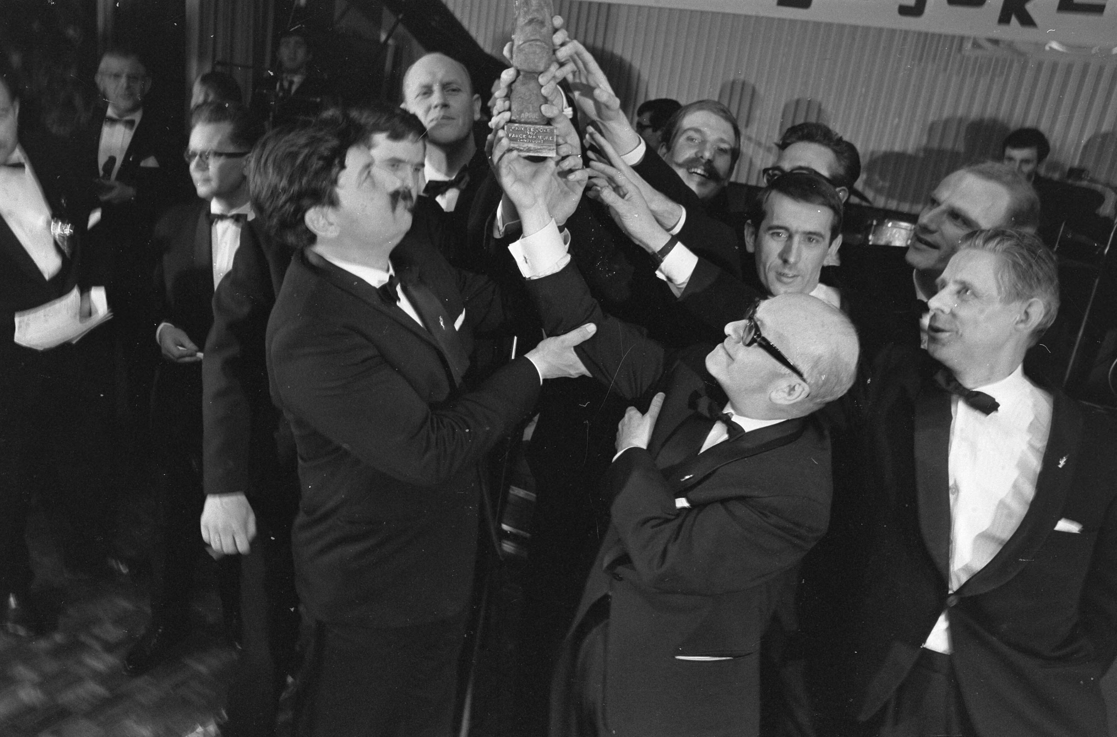 Fotocollectie Anefo — n het hotel Bouwes te Zandvoort werd zaterdagavond de Prix de Joke uitgereikt aan de groep "Farce Majeure", beeldje in handen van Fred Benavente 9links) en Alexander Pola (rechts) — Foto: Nijs, Jac. de / Anefo. Licentie: Set B: Rechtenvrij / Publiek Domein. Bron: Nationaal Archief. http://hdl.handle.net/10648/ab1449a8-d0b4-102d-bcf8-003048976d84