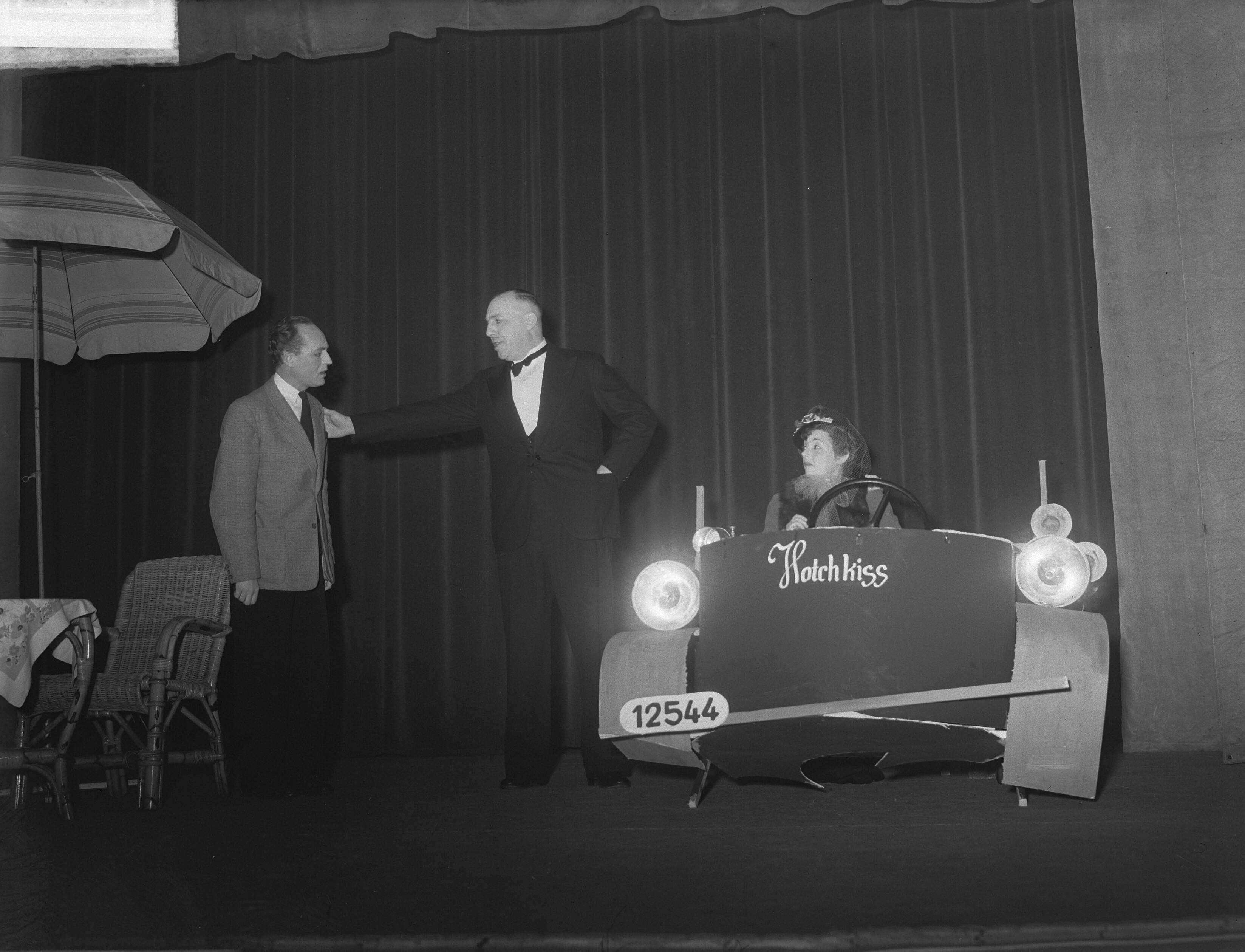 Congres van "Het Groene Kruis" in Utrecht — Congres van "Het Groene Kruis" in Utrecht [Cabaret? Man in rokkostuum met rechts een decorstuk, voorstellende een Hotchkiss auto met achter het stuur een vrouw] — Foto: Pot, Harry / Anefo. Licentie: Set B: Rechtenvrij / Publiek Domein. Bron: Nationaal Archief. http://hdl.handle.net/10648/a8df25d6-d0b4-102d-bcf8-003048976d84