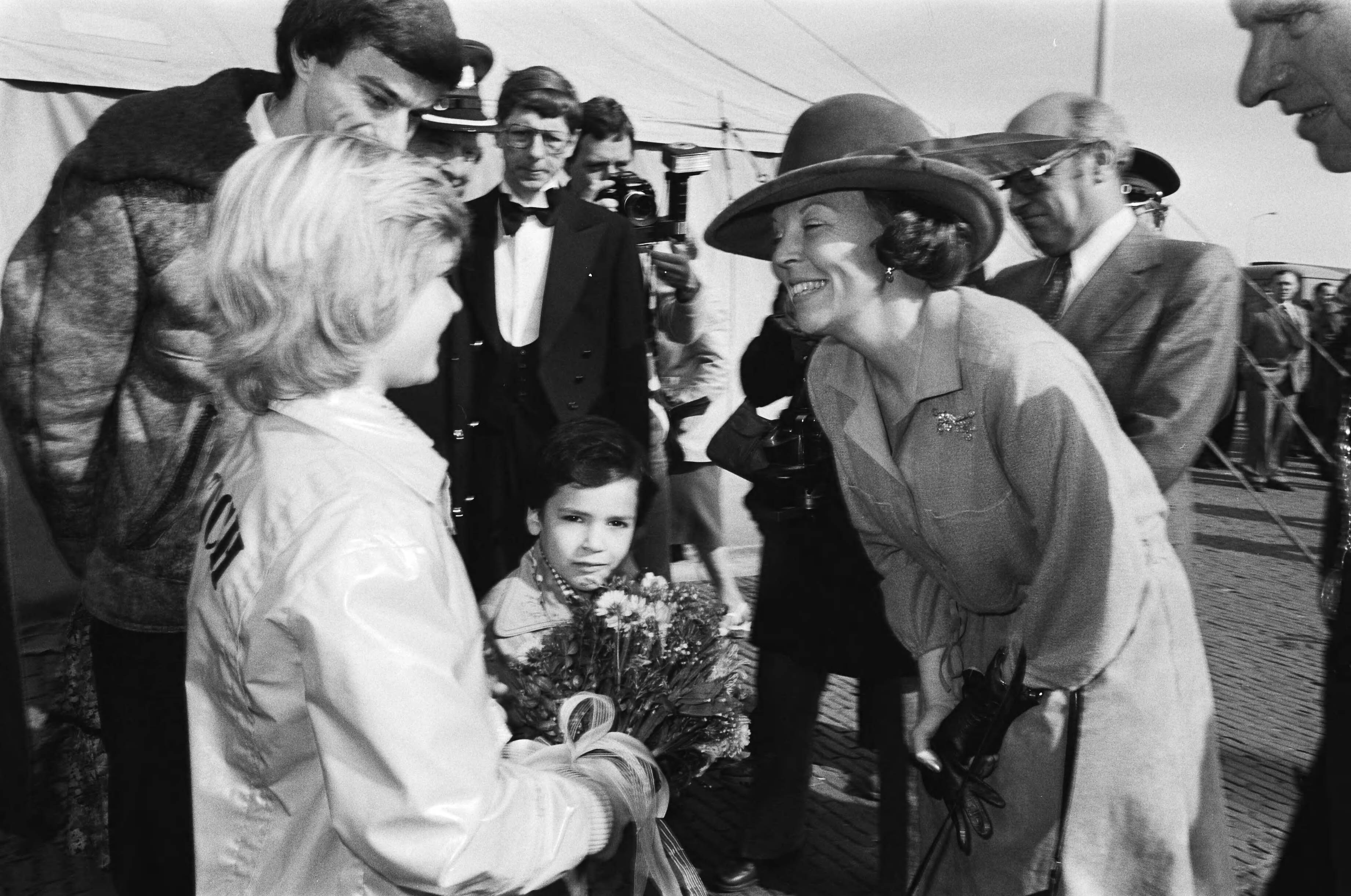 Prinses Beatrix onthult het monument "75 jaar havens" in Scheveningen — Prinses Beatrix ontvangt bloemen — Foto: Suyk, Koen / Anefo. Licentie: Set B: Rechtenvrij / Publiek Domein. Bron: Nationaal Archief. http://hdl.handle.net/10648/acc9c80e-d0b4-102d-bcf8-003048976d84