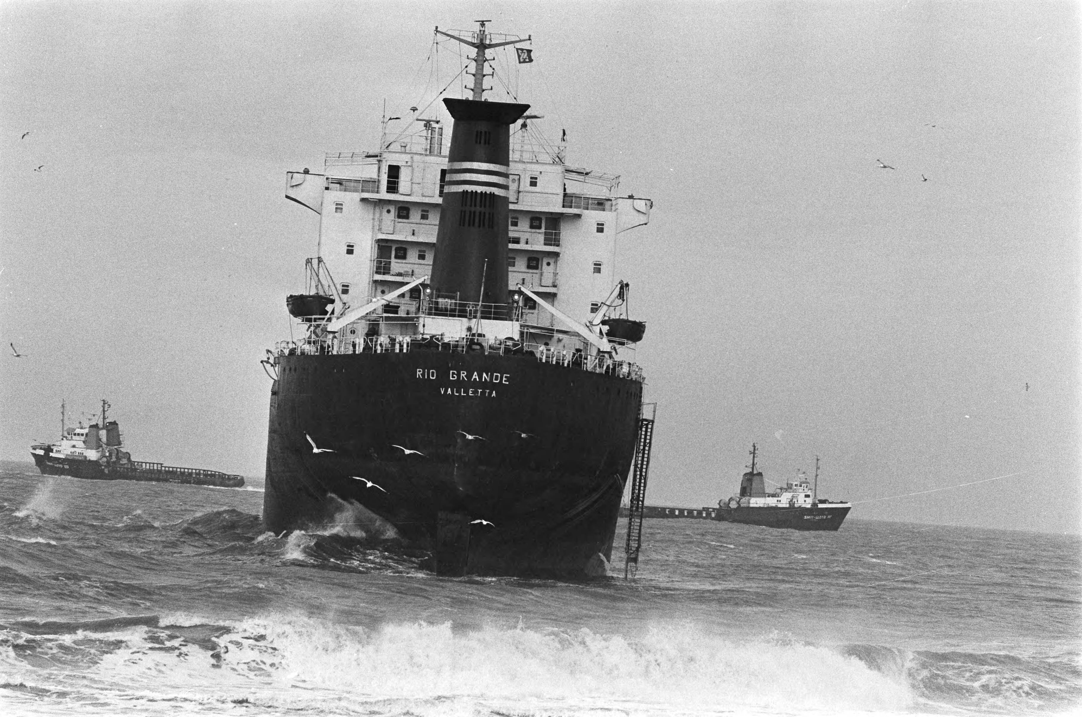 Rio Grande op het strand van Wassenaar — 2 zeeslepers bezig met het gestrande schip — Foto: Bogaerts, Rob / Anefo. Licentie: Set B: Rechtenvrij / Publiek Domein. Bron: Nationaal Archief. http://hdl.handle.net/10648/ad4effec-d0b4-102d-bcf8-003048976d84