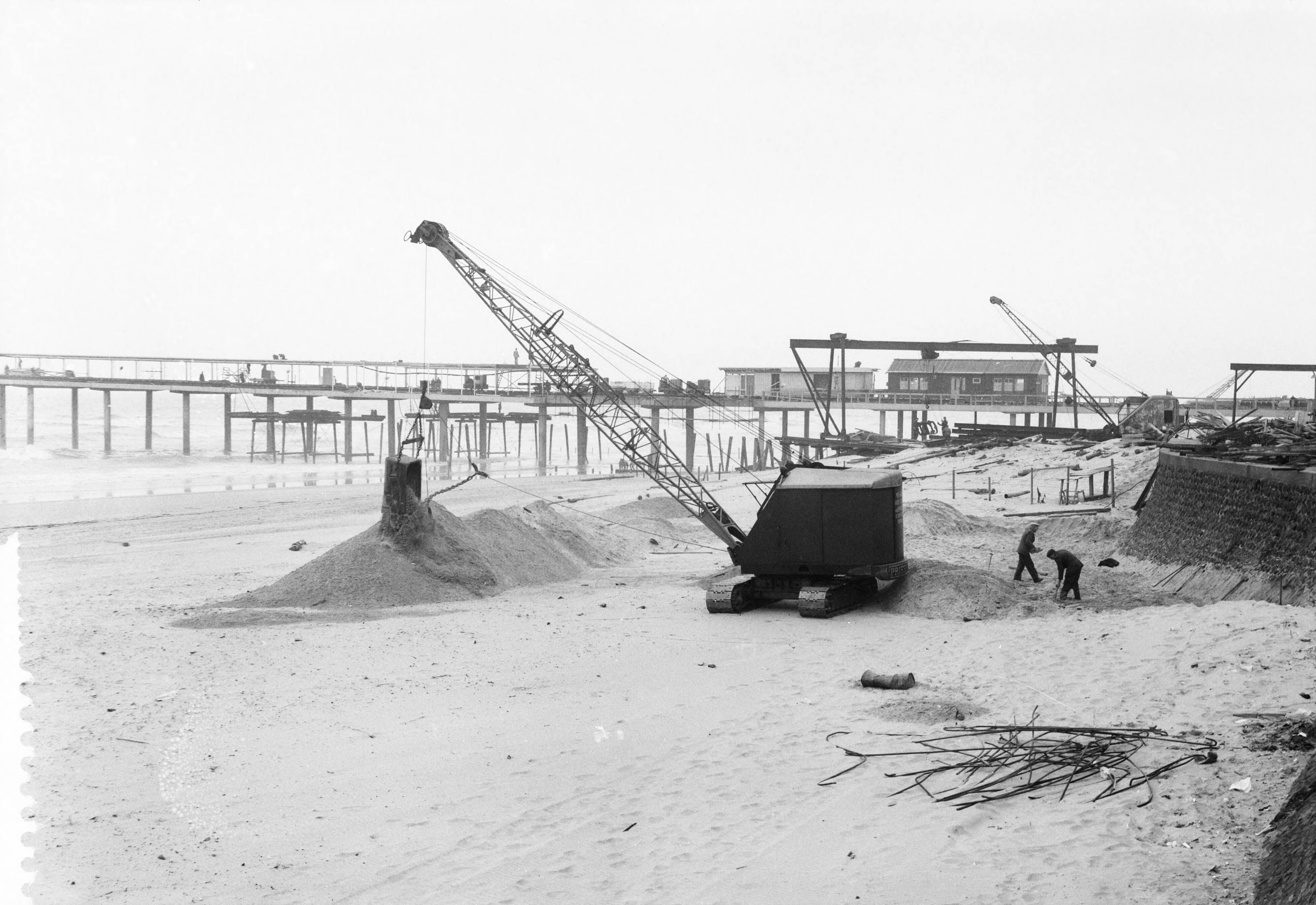 Fotocollectie Anefo — Egaliseren van het strand te Scheveningen voor het komend badseizoen — Foto: Behrens, Herbert F. / Anefo. Licentie: Set B: Rechtenvrij / Publiek Domein. Bron: Nationaal Archief. http://hdl.handle.net/10648/a9ccf2b6-d0b4-102d-bcf8-003048976d84