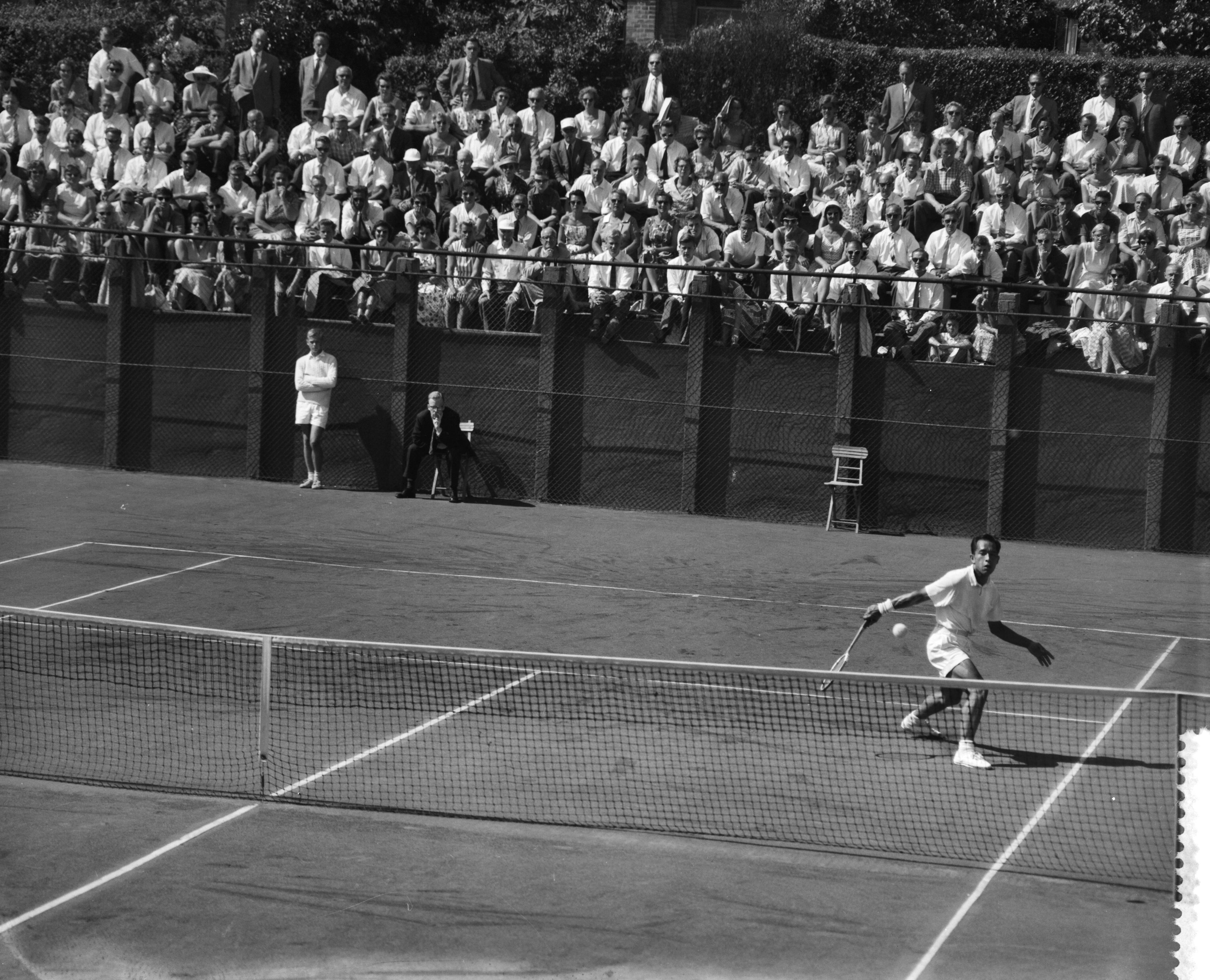 Fotocollectie Anefo — Nederlandse tenniskampioenschappen op de METS-banen te Scheveningen, Lex Karamoy in aktie — Foto: Behrens, Herbert F. / Anefo. Licentie: Set B: Rechtenvrij / Publiek Domein. Bron: Nationaal Archief. http://hdl.handle.net/10648/a99b45b8-d0b4-102d-bcf8-003048976d84