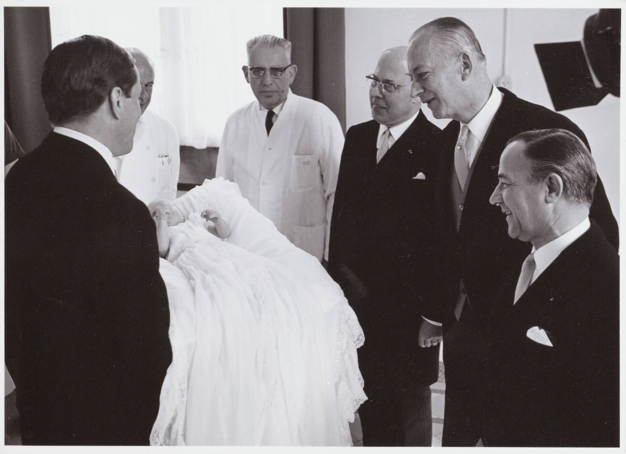 Fotocollectie RVD / Koninklijk Huis — Prins Claus toont de baby prins Willem-Alexander aan de doktoren in het Academisch Ziekenhuis Utrecht op 2 mei 1967 — Foto: Nationaal Foto Persbureau / RVD. Licentie: Set B: Rechtenvrij / Publiek Domein. Bron: Nationaal Archief. http://hdl.handle.net/10648/afaf2f5a-d0b4-102d-bcf8-003048976d84