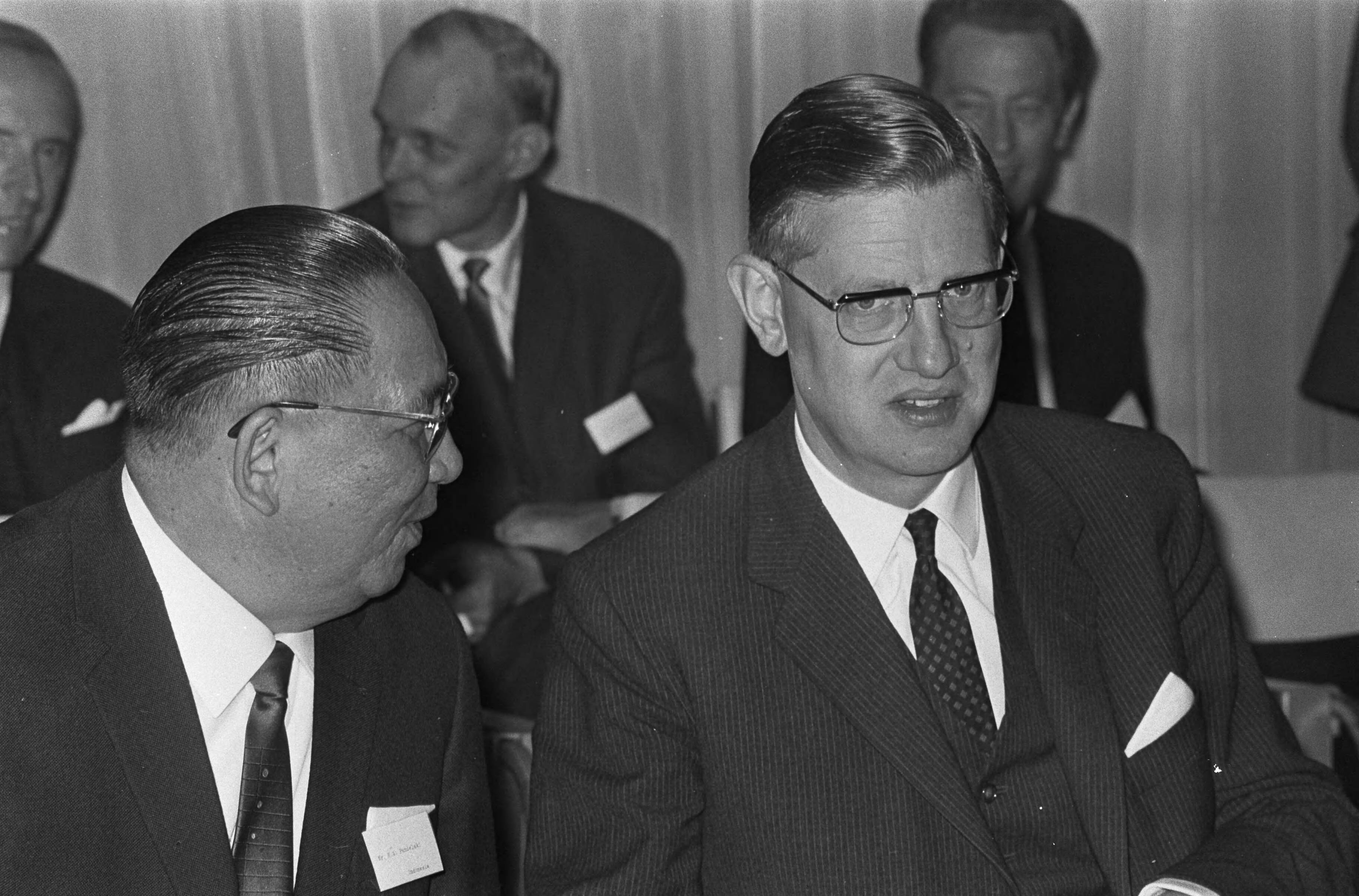 Conferentie van de Intergouvernementele Groep te Scheveningen — Rechts conferentievoorzitter minister (zonder portefeuille) Berend-Jan Udink, links naast hem mr. H. A. Pandelaki — Foto: Fotograaf Onbekend / Anefo. Licentie: Set B: Rechtenvrij / Publiek Domein. Bron: Nationaal Archief. http://hdl.handle.net/10648/ab1c97f2-d0b4-102d-bcf8-003048976d84