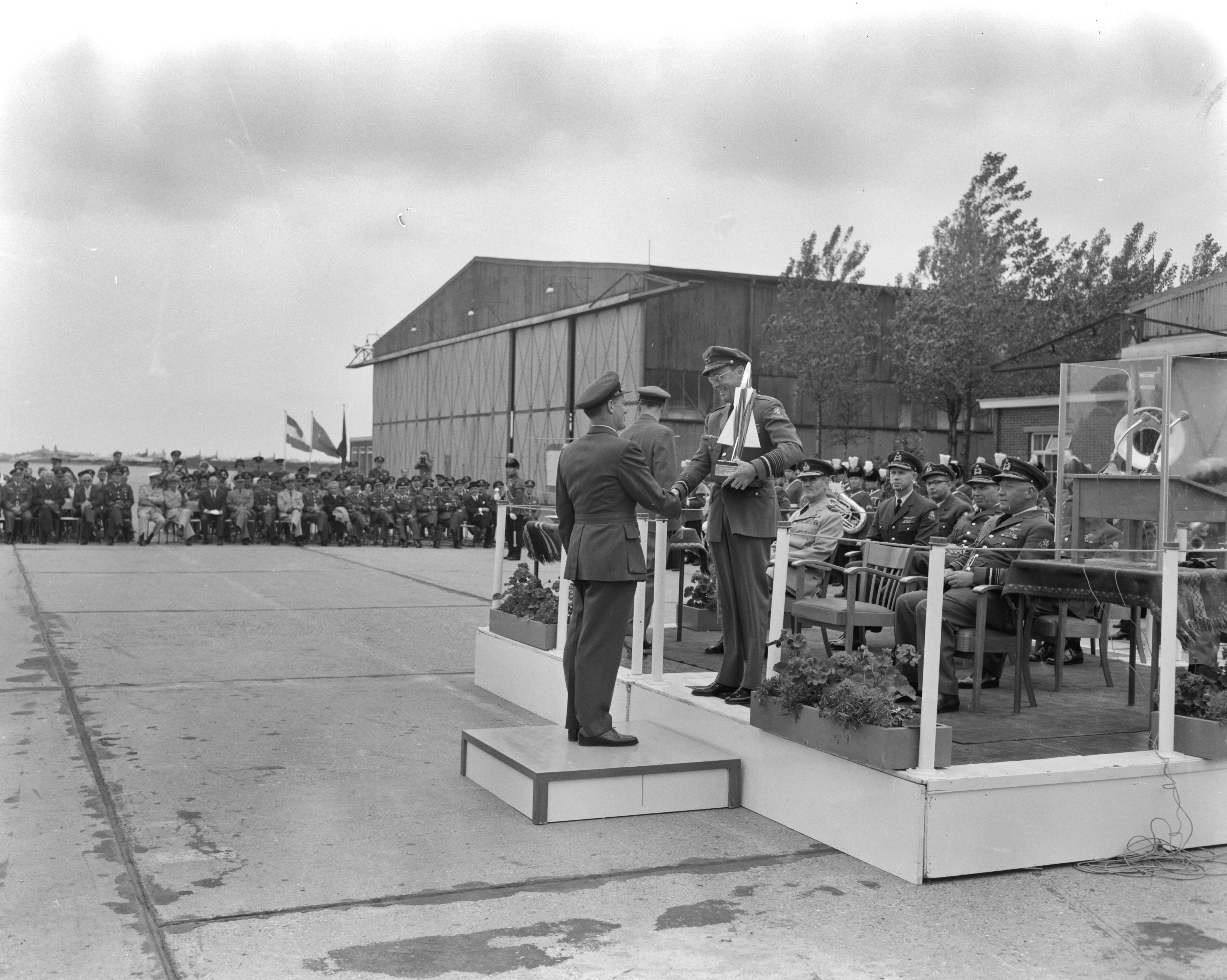 Fotocollectie Anefo — Prins Bernhard reikt in Leeuwarden prijzen uit van 5e Aircent-schietcompetitie van de NAVO luchtmacht. Brian Mercer "squadron-leader" van de winnende Britse ploeg ontving uit handen van de prins de Guynemertrofee — Foto: Bilsen, Joop van / Anefo. Licentie: Set B: Rechtenvrij / Publiek Domein. Bron: Nationaal Archief. http://hdl.handle.net/10648/aa0d63c8-d0b4-102d-bcf8-003048976d84