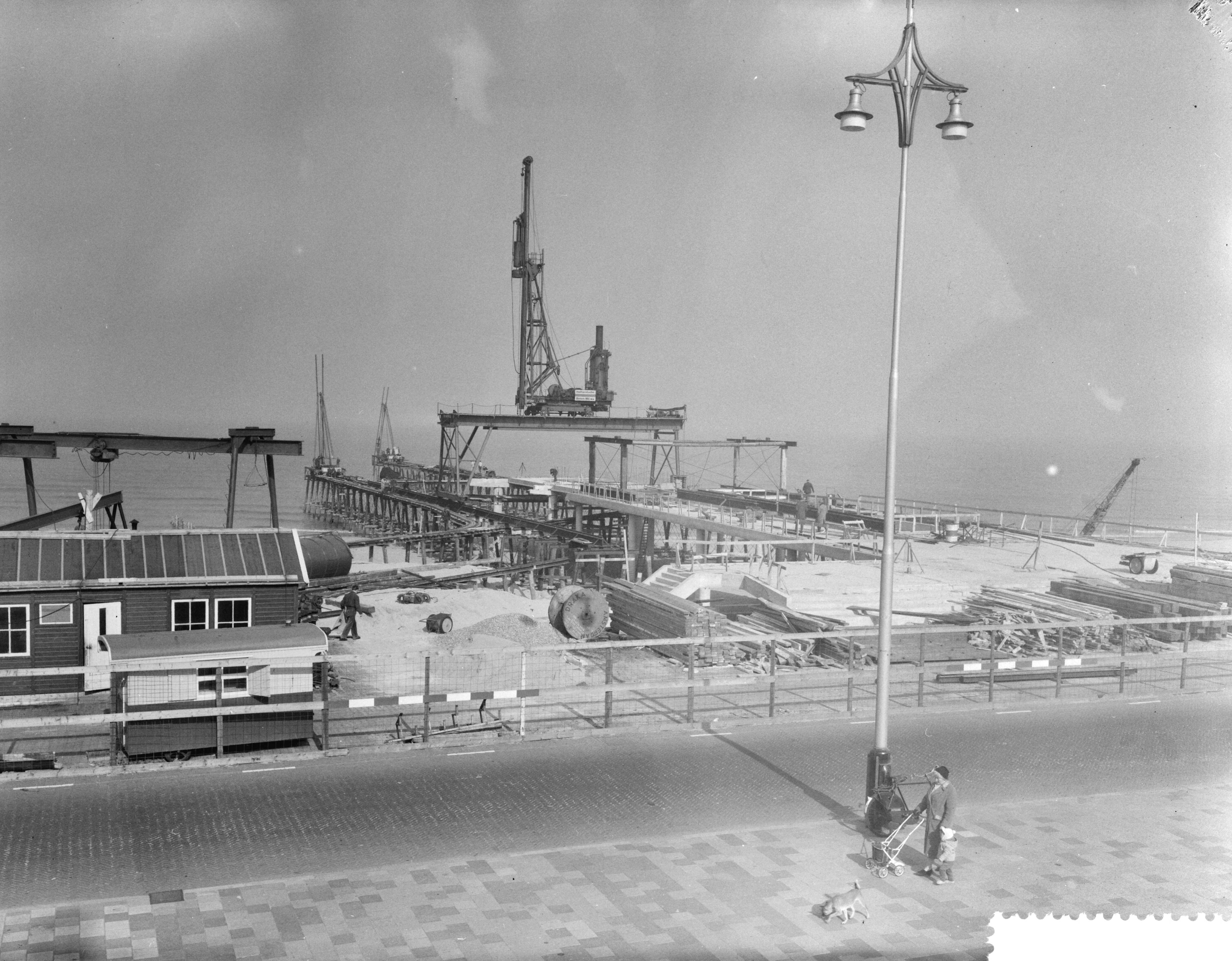 Fotocollectie Anefo — Bouw pier te Scheveningen — Foto: Behrens, Herbert F. / Anefo. Licentie: Set B: Rechtenvrij / Publiek Domein. Bron: Nationaal Archief. http://hdl.handle.net/10648/a9aad1d6-d0b4-102d-bcf8-003048976d84