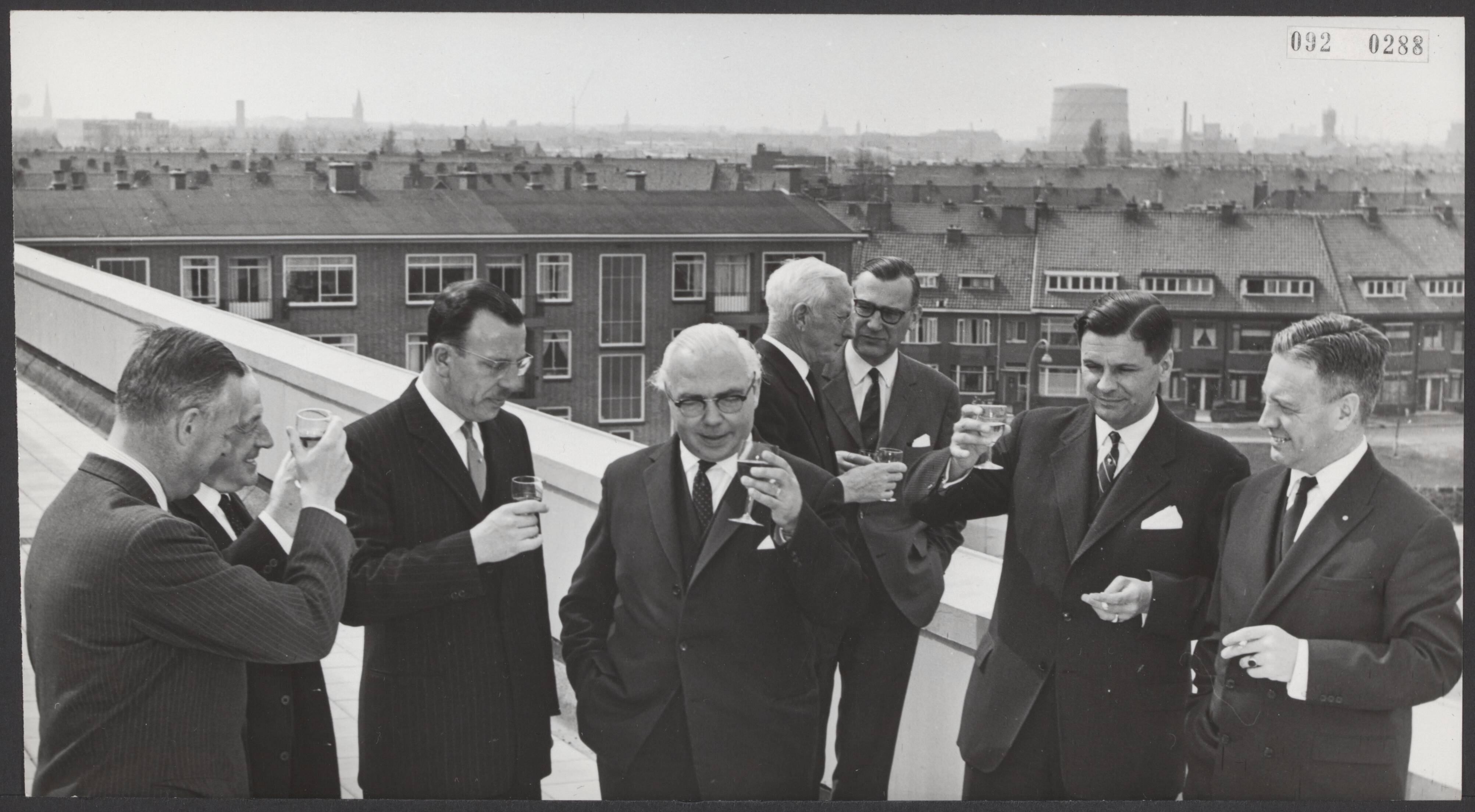 Fotocollectie Elsevier Binnenland — In Voorburg heeft minister dr. G.MJ. Veldkamp het nieuwe gebouw van de Directie van de Arbeid geopend. Op het dakterras werd een heildronk uitgebracht. Vlnr. jhr. A. Feith, burgemeester van Voorburg; de heer Valentgoed, dir. Rijksarbeidsinspectie; drs. van de Laar, staatssecretaris O.K. en W.; minister Veldkamp; de heer Hodke, dir. Monumentenzorg en dr. de Meijer, staatsecretaris Sociale Zaken — Foto: Koch, Eric / Anefo. Licentie: Set B: Rechtenvrij / Publiek Domein. Bron: Nationaal Archief. http://hdl.handle.net/10648/ae2392de-d0b4-102d-bcf8-003048976d84